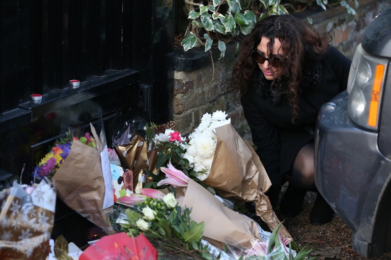 People lay bunches of flowers in tribute outside the north London home of British singer George Michael on December 26, 2016, after news of the singer's death broke. Tributes poured in from the music world on December 26 after British pop superstar George Michael, who rose to fame with the duo Wham! and a string of smash hits including "Last Christmas", died aged 53. Michael died of apparent heart failure on Christmas Day at his home in Goring, a village on the River Thames in Oxfordshire, west of London, after an award-winning career spanning more than three decades. / AFP PHOTO / Daniel LEAL-OLIVAS